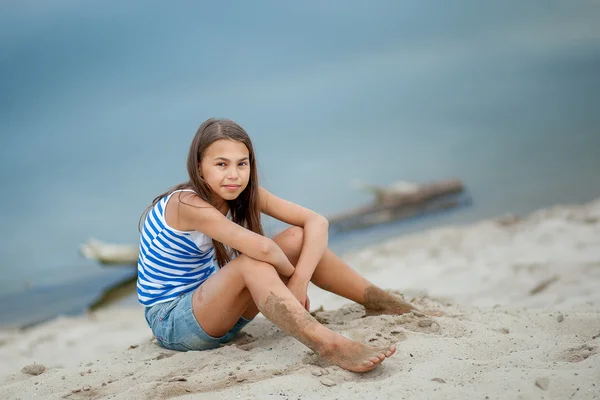 Девушка в полосатом жилете на песке — стоковое фото