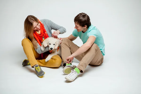 Par som leker med en hund – stockfoto