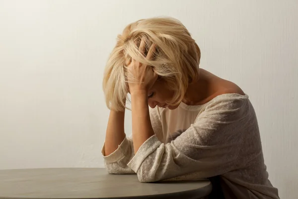 Beautiful woman sitting at the table — Stock Photo, Image