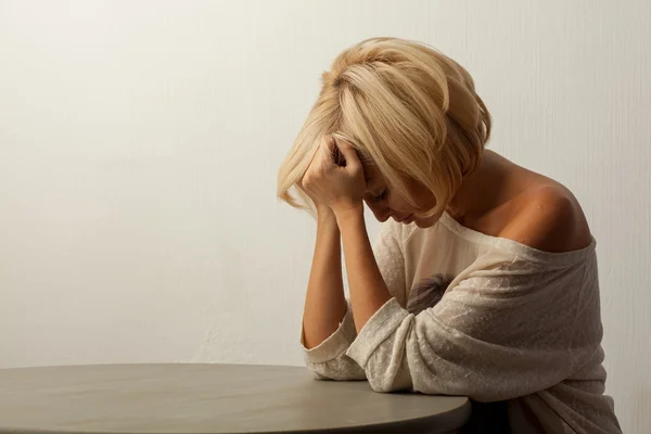 Mooie vrouw zitten aan de tafel Stockafbeelding