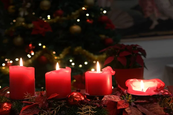クリスマス4キャンドル炎赤 背景にライトアップされた木の花 — ストック写真