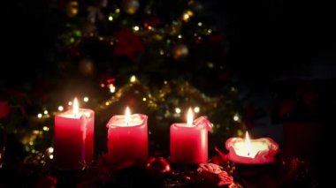 Noel 4 mumları kırmızı ve arka planda ışıklandırılmış ağaç