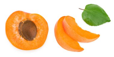 Dilimlenmiş kayısı meyveleri ve beyaz arka planda izole edilmiş yeşil yaprak. Kesme yolu. en üstteki görünüm