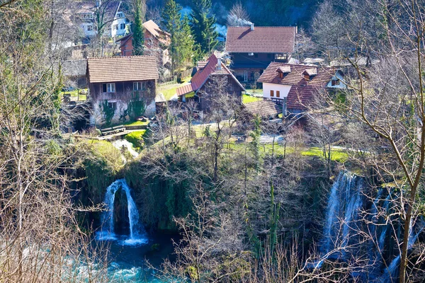 Растоке село водоспадом та дерев'яних котеджів — стокове фото