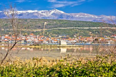 Posedarje kıyı kasabası ve Croati 'nin Dalmaçya bölgesindeki küçük ada kilisesi manzarası