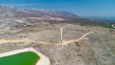 Velebit dağ manzaralı rüzgar türbinleri, Hırvatistan 'ın terk edilmiş Dalmaçya bölgesindeki terk edilmiş fabrikanın Alkalin havuzu