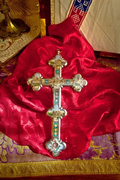 Golden catholic cross on red cloth — Stock Photo, Image