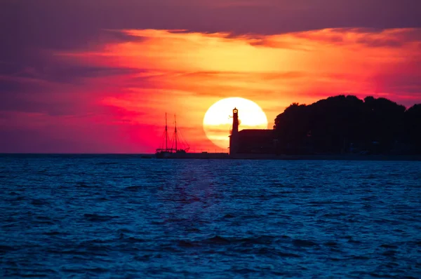 Vedere epică la apus de soare cu far și barcă cu saiboat — Fotografie, imagine de stoc