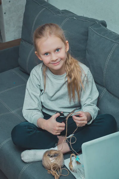 Une fille caucasienne est engagée dans un passe-temps à la maison étudiant sur un ordinateur portable en regardant une leçon vidéo à la maison — Photo