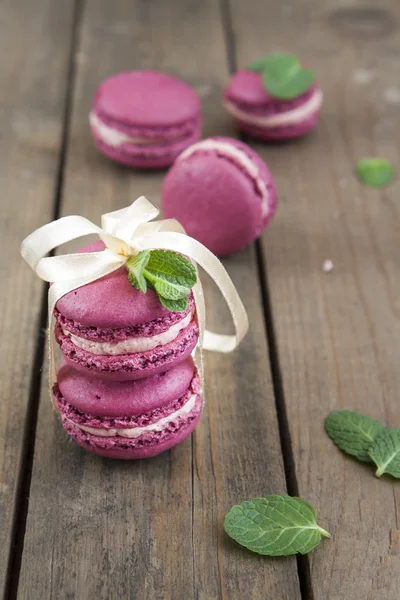 Sweet crimson french macaroons wiht hyacinth flowers and mint on dark wooden background — Stock Photo, Image