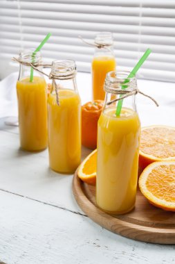 Taze portakal ile küçük şişelerde doğal ve taze portakal suyu