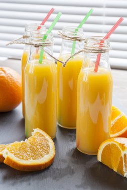 Taze portakal ile küçük şişelerde doğal ve taze portakal suyu