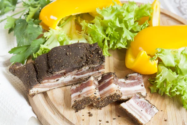 Een heerlijke gerookte ribbetjes met specerijen rond verse gele peper Sla peterselie op houten bord en Servet achtergrond — Stockfoto