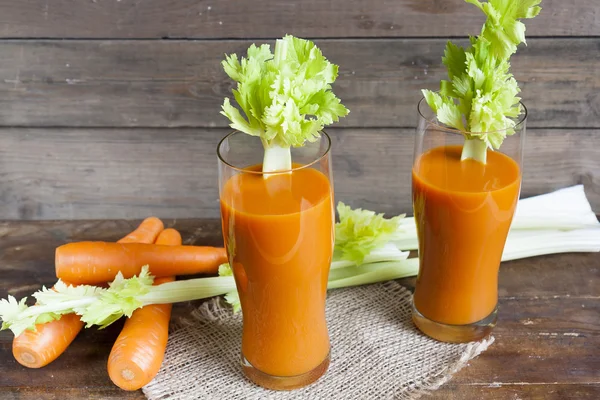 Taze havuç suyu ile havuç ve kereviz koyu ahşap arka plan üzerinde