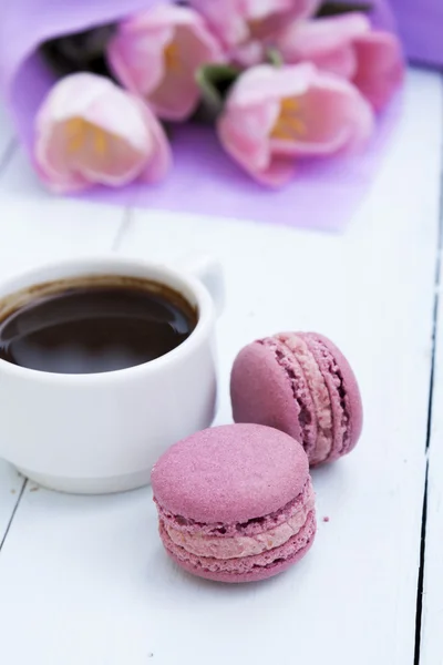 Cup of coffee and two pink macaroons on light wooden background — Stock Photo, Image
