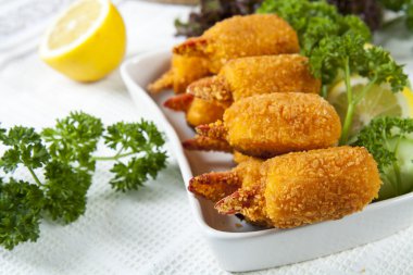 Fried Yengeç pençeleri salatalık, limon, marul ve maydanoz ile