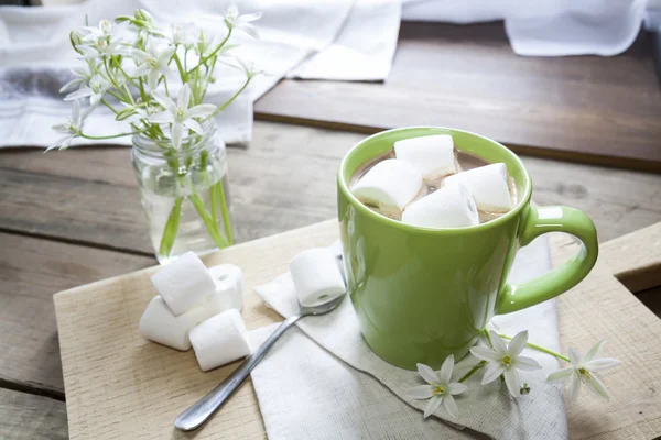 Hot cocoa with marshmallows in green cup