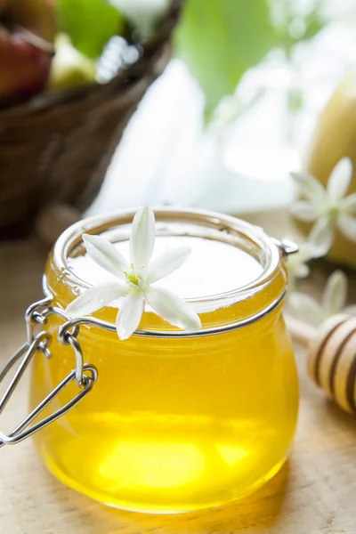 テーブルの上の蜂蜜と白の花 — ストック写真