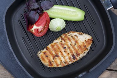 Sebze ve bitkilerle ızgara tavuk göğsü.