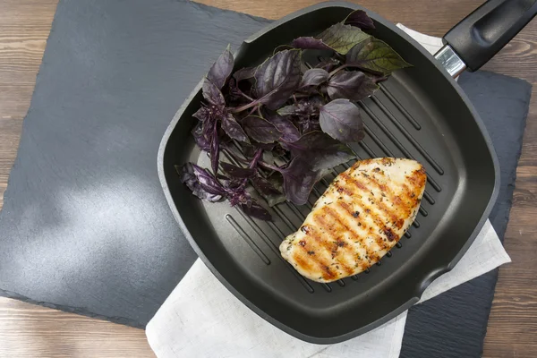 Izgara tavuk göğsü biftek üzerinde teflon tava gri mor fesleğen ile