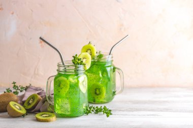 Bir kavanoz kivi suyu veya smoothie. Kiwi Mojito kokteyli ya da alkolsüz mocktail naneli ve dilimlenmiş kivi meyveli ahşap arka planda fotokopi alanı
