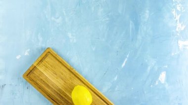 Ginger, honey, lemon and lime herbal tea preparation with high levels of Vitamin C, boosting the immune system. Top view, blue table surface. Stop motion animation. 