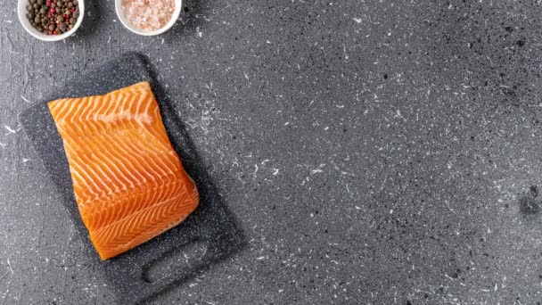 Raw salmon fillet and ingredients for cooking, seasonings and herbs on a dark background. Stop motion animation, top view. — Stock Footage Raw Salmon Fillet Ingredients Cooking Seasonings Herbs Dark Background Stop Royalty Free Stock Video