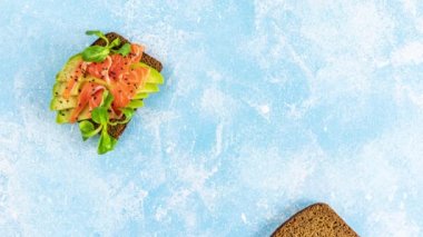 Sağlıklı atıştırmalıkların veya somon, avokado, karides, yumurta, salatalık, kuzu salatası veya mısır salatası ve maydanozlu kızarmış ekmeğin hareketli animasyonunu durdurun. Aşama aşama yiyecek hazırlama, üst görünüm videosu