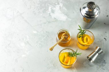  Biberiye şurubu ya da ev yapımı viski kokteyli. Portakal ve biberiyeli. Portakal kabuğunu süsleyin. Hafif beton yüzey