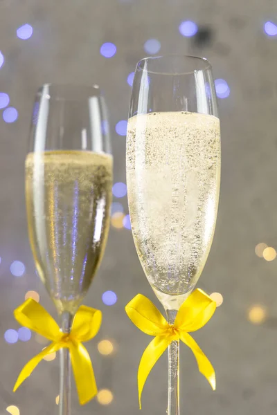 Two Champagne Glasses Yellow Bows Gray Background Bokeh Lights Shallow — Stock Photo, Image