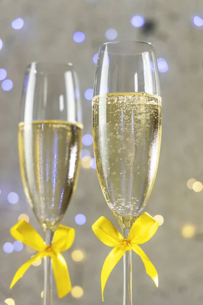 Two Champagne Glasses Yellow Bows Gray Background Bokeh Lights Shallow — Stock Photo, Image