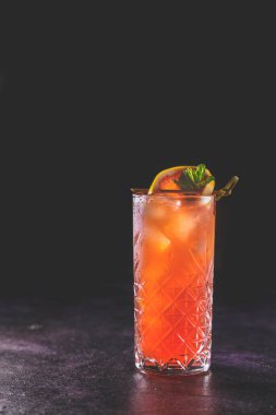 Pembe Greyfurt Mezcal Paloma Kokteyli. Viski bardağında su damlaları var. Yaklaş, alanın sığ derinliği, koyu arkaplan.