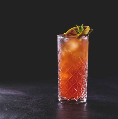 Pembe Greyfurt Mezcal Paloma Kokteyli. Viski bardağında su damlaları var. Yaklaş, alanın sığ derinliği, koyu arkaplan.