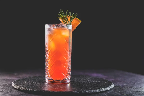 Pembe Greyfurt Mezcal Paloma Kokteyli viski bardağında. Gerçek evdeki masada su damlaları var. Yeni yaşam konsepti karantina. Yaklaş, alanın sığ derinliği