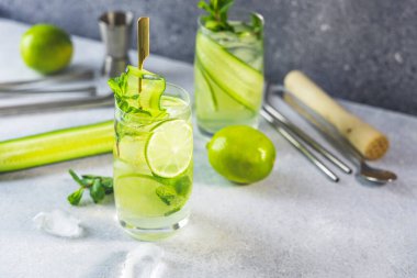 Nane, salatalık ve limonlu detoks kokteyli veya gri beton yüzey zemininde viski bardaklarında mojito kokteyli. Metnin için kopyalama alanı ile