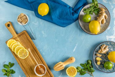 Zencefil, bal, limon ve limonlu bitki çayı. Yüksek dozda C vitamini, bağışıklık sistemini güçlendirir. Üst görünüm, mavi tablo yüzeyi.