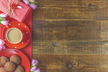 Sabah kahvesi, çikolatalı kek, hediye ya da hediye kutusu, yukarıdaki ahşap masada mumlar ve çiçek. Romantik Sevgililer Günü yemek geçmişi. Üst görünüm, metin için boşluk kopyala.