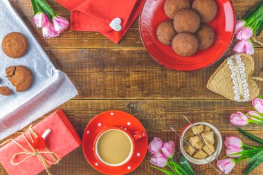 Sabah kahvesi, çikolatalı kek, hediye ya da hediye kutusu, yukarıdaki ahşap masada mumlar ve çiçek. Romantik Sevgililer Günü yemek geçmişi. Üst görünüm, metin için boşluk kopyala.