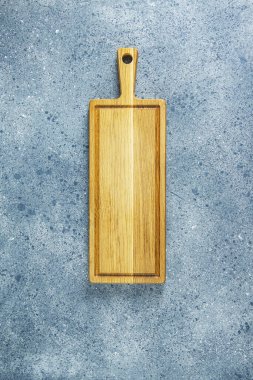 Mutfak gereçleri arka planı. Gri masa yüzeyinde tahta kesme tahtası.