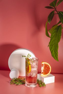 Buzlu, biberiyeli ve pembe masa yüzeyinde kekik bulunan viski bardağı taze greyfurt kokteyli..