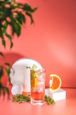 Buzlu, biberiyeli ve pembe masa yüzeyinde kekik bulunan viski bardağı taze greyfurt kokteyli..