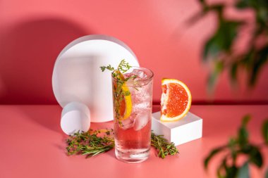 Buzlu, biberiyeli ve pembe masa yüzeyinde kekik bulunan viski bardağı taze greyfurt kokteyli..