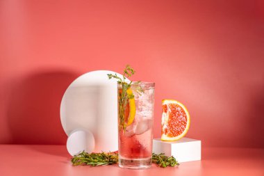 Buzlu, biberiyeli ve pembe masa yüzeyinde kekik bulunan viski bardağı taze greyfurt kokteyli..