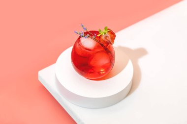 Çilekli lavantalı mojito kokteyli brendi bardağında buzlu pastel üzerine su damlaları parlak güneş ışığında yumuşak pembe arka plan, beyaz tahta. Kopyalama alanı, yaz tatili ve parti konsepti