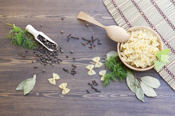Pasta mit Kräutern und Gewürzen auf dunklem Holztisch — Stockfoto