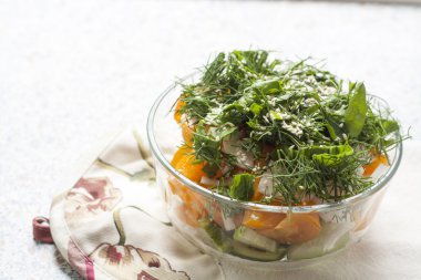 salata taze sarı domates ve salatalık ile otlar ve susam bir tabloda bir cam kasede