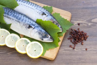 limon dilimleri ile taze uskumru üzüm yaprakları