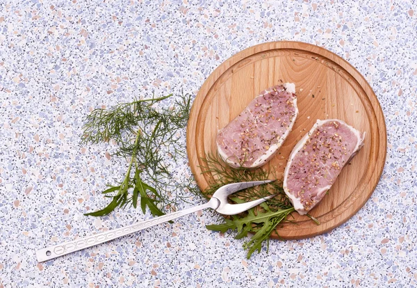 Vers rauw vlees met spaties en kruiden op houten bord in tabel — Stockfoto