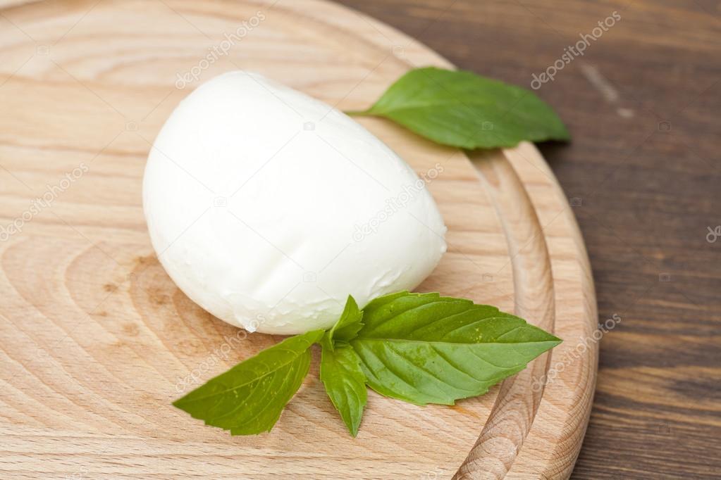 Mozzarella with herbs on a round wooden board