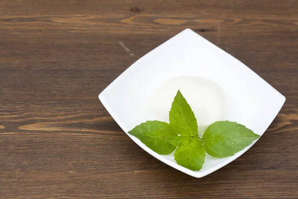 Mozzarella with herbs in a white rectangular bowl on wooden table, selective focus — Stock Photo, Image